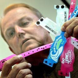 Precision Dynamics Vice President Robin Barber holding RFID wristbands