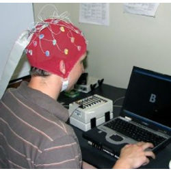 laptop user wearing EEG recording cap