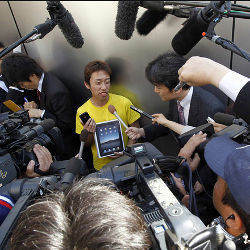 Takechiyo Yamanaka surrounded by reporters