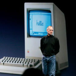 Steve Jobs and image of an early Apple desktop 