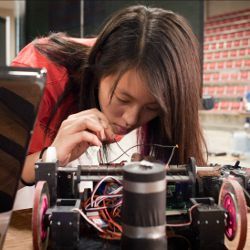 student adjusts her robot