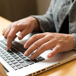 hands on laptop keyboard