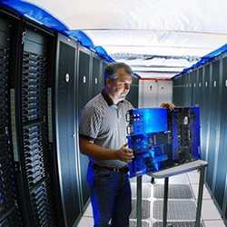 A researcher inspects a supercomputer component. 