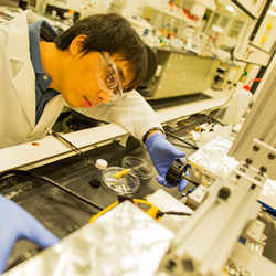 A doctoral students sets up the equipment to apply plastic semiconductors.