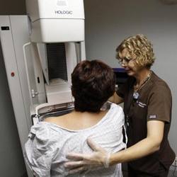 A medical technician performing a mammography on a woman.