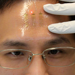 A man wearing a patch with electronic circuits on his forehead.