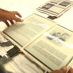 A user handling the e-ink displays of the Paper Tab project. 