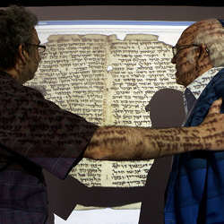 Two men examine an image of a document fragment.
