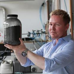 Associate professor Kasper Norgaard holds a jar of graphite, the precursor of graphene..