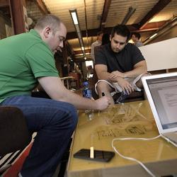 A developer sketches a navigation system for an application with an intern.