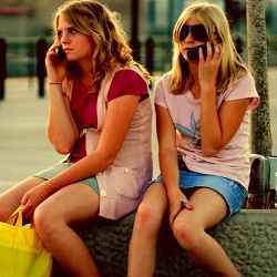 Two teens taking a phone break while shopping.