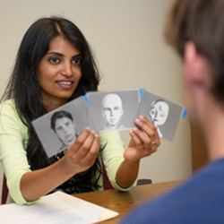 Graduate student Akanksha Prakash shows a study participant potential robot faces. 