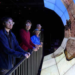 Researchers view a demo of the Wide-Angle Virtual Environment (WAVE) display.