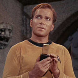 Star Trek's Captain Kirk using his communicator. 