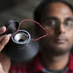 Graduate student Apoorva Kiran holds a 3-D printed, fully functional loudspeaker.