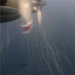 Plane flying over oil slick