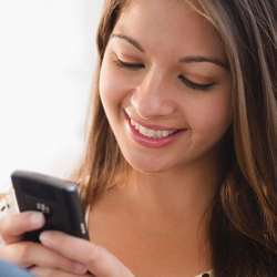 A young woman smiles at a Facebook post she receives.