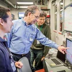 Nicholas Sauter, center, a computer staff scientist at Lawrence Berkeley National Laboratory, points to a monitor during an experiment at SLAC's Linac Coherent Light Source X-ray laser.