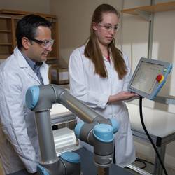 Facundo Fernandez (left) and Rachel Bennett use a robotic arm to probe objects with irregularly-shaped surfaces for mass spectrometry.