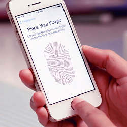 Using the Touch ID feature on Apple's iPhone 5s handset. 