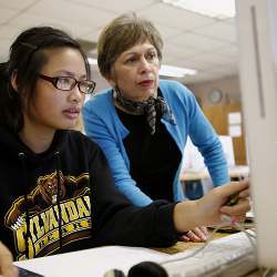 Shubha Tuljapurkar, director of educational technology startup Globaloria, an educational tech startup, works with Kayla Pham, 14, during an eighth-grade computer science class at Sylvandale Middle School in San Jose. 