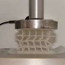 A 3D-printed wax-coated flexible scaffold being compressed in a temperature-controlled chamber. 