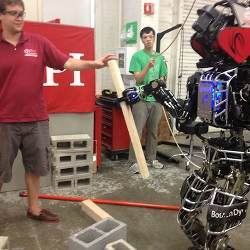 The robot Warner grasps a wood board on its own as WPI team leader Matt DeDonato observes.