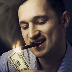 An apparently rich person lighting his cigar with a $100 bill. 