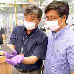 Jiyoung Kim and Kyeongjae Cho examine a wafer used to make transistors. 