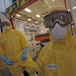 A medical team waits in front of an ambulance during a training exercise on handling suspected Ebola cases in Paris.