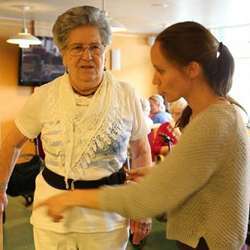 A researcher helps Skjoldvor Msval, resident at the Laugsand day care center, adjust the belt that will trigger an alarm if she falls.  