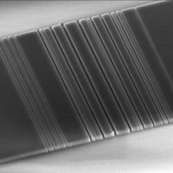 A tiny slice of silicon, etched with a pattern that resembles a bar code.