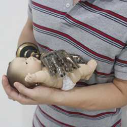 A prosthetic hand equipped with the proposed prosthetic skin is used just like an actual hand to cuddle a baby doll. 