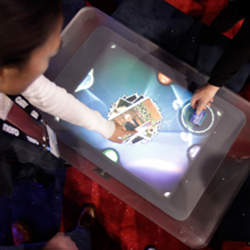 Users manipulate content on an interactive surface.