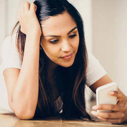 A young woman perplexed by her smartphone.