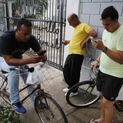 In search of an Internet connection, Cubans check their phones outside a center run by a Havana artist who offers access to his Wi-Fi network for free.