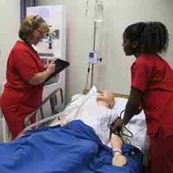 Nurses practice taking blood pressure and collecting medical history with a traditional human patient simulator system. 