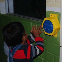 A chiled in an orphanage in Ecuador tries out the communications button.