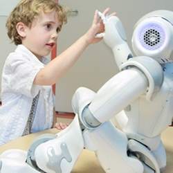 A child interacts with a Nao robot. 