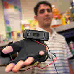 Graduate student Siddharth Advani displays a webcam-equipped haptic glove he helped design to help visually-impaired people shop for groceries.