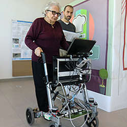 An elderly user tries out the c-Walker robotic cognitive walker. 