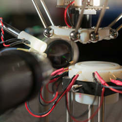 A fruit fly hangs unharmed at the end of the robot's suction tube.