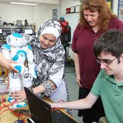Holly Yanco (in purple) and students at the University of Massachusetts Lowell work on a robot. 