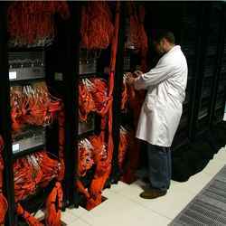 A technician adjusts a network cable in an IBM supercomputer.