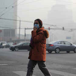 A woman wearing a face mask makes her way along a street in Beijing.