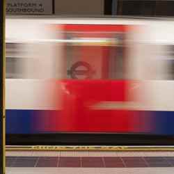 A train speeds through a London Underground station.