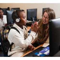 A student learning to code at DuBose Middle School in Summerville, SC, high-fives a member of Google's CS First teaching program.