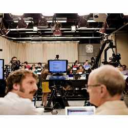 Two professors at the University of Texas at Austin deliver their lecture in front of a camera crew.