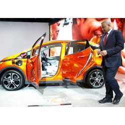 U.S. Transportation Secretary Anthony Foxx stands beside a Chevrolet Bolt EV at the North American International Auto Show in Detroit.