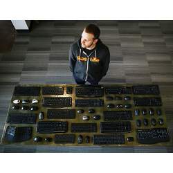 Security researcher Marc Newlin, with wireless peripherals he found vulnerable to a radio keystroke injection attack.